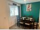 A modern dining area featuring a wooden table, chairs, and a vibrant green accent wall with decorative artwork at 2872 Atomic Tangerine Way # 2, Las Vegas, NV 89183