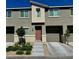 Modern townhome featuring a warm toned front door, attached garage, and low-maintenance landscaping at 2872 Atomic Tangerine Way # 2, Las Vegas, NV 89183