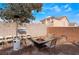 Relaxing backyard with brick pavers, an outdoor fireplace, patio seating, and mature trees at 2903 Galena Peak Ln, Las Vegas, NV 89156