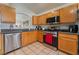 Well-lit kitchen showcasing stainless steel appliances, wood cabinets, and tile flooring at 2903 Galena Peak Ln, Las Vegas, NV 89156