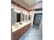 Bathroom with double sink vanity, tile floors, large mirrors, and a step-in shower at 2925 Big Green Ln, Las Vegas, NV 89134