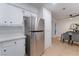 Bright kitchen featuring stainless steel refrigerator, white cabinets, and tile flooring at 3151 Soaring Gulls Dr # 1168, Las Vegas, NV 89128