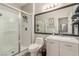 Bright bathroom featuring a glass-enclosed shower, a toilet and vanity with framed mirror at 3845 Wiggins Bay St # 202, Las Vegas, NV 89129