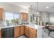 Bright kitchen with white counters, wood cabinets, stainless steel appliances, and view to living area at 3845 Wiggins Bay St # 202, Las Vegas, NV 89129