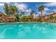Large community pool with lounge chairs and shaded cabanas, surrounded by lush landscaping and palm trees at 3845 Wiggins Bay St # 202, Las Vegas, NV 89129