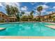 Large community pool with lounge chairs and shaded cabanas, surrounded by lush landscaping and palm trees at 3845 Wiggins Bay St # 202, Las Vegas, NV 89129