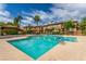 Community pool surrounded by palm trees and lounge chairs at 3845 Wiggins Bay St # 202, Las Vegas, NV 89129