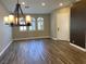 Inviting dining room featuring wood-look tile flooring, a chandelier, and sunlit windows with shutters at 3882 Genoa Dr, Las Vegas, NV 89141
