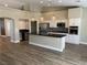 Modern kitchen with white cabinets, dark countertops, stainless steel appliances, and wood-look tile flooring at 3882 Genoa Dr, Las Vegas, NV 89141