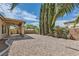Stone-filled backyard with a covered patio and mature landscaping at 427 Rhythm St, Henderson, NV 89074