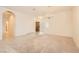 Living room featuring neutral carpet, arched entryway, and tile floors leading to a wooden front door at 427 Rhythm St, Henderson, NV 89074