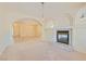 Living room with tile floors, plush carpet, a fireplace, arched entryways, and decorative lighting at 427 Rhythm St, Henderson, NV 89074