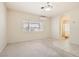 Main bedroom featuring plush carpet, a ceiling fan, and an en suite bathroom with tile floors at 427 Rhythm St, Henderson, NV 89074