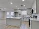 A well-lit kitchen features a quartz countertop island, grey cabinets and modern appliances at 4360 El Tovar Rd, Las Vegas, NV 89115