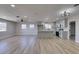 Open-concept living room with light wood flooring, neutral paint, updated ceiling fan, and remodeled kitchen at 4360 El Tovar Rd, Las Vegas, NV 89115
