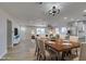 Staged living room with light wood flooring, neutral paint, a dining table and views of the kitchen at 4360 El Tovar Rd, Las Vegas, NV 89115