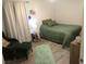 Comfortable bedroom with green bedding, chair, and ottoman at 4361 Duck Harbor Ave, North Las Vegas, NV 89031
