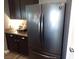 Modern stainless steel refrigerator complimenting the dark wood cabinets and granite countertops at 4361 Duck Harbor Ave, North Las Vegas, NV 89031