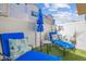 Relaxing backyard patio with lounge chairs, a shade umbrella, and artificial turf at 4465 Shimmering Skies St # 1177, North Las Vegas, NV 89031