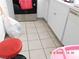 Tiled kitchen with white appliances and cabinetry, featuring a gas stove, along with a red chair at 4663 Sand Creek Ave, Las Vegas, NV 89103