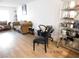 Casual living room with minimal furnishings including a wicker sofa, decorative chairs, and laminate flooring at 4663 Sand Creek Ave, Las Vegas, NV 89103