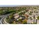 Expansive aerial view of a vibrant residential neighborhood with lush greenery and well-maintained homes in a desert setting at 504 Painted Cloud Pl, Las Vegas, NV 89144