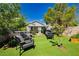 Backyard featuring a covered patio, lounge area, lush turf, and mature landscaping for relaxation and outdoor entertainment at 504 Painted Cloud Pl, Las Vegas, NV 89144