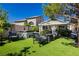 Backyard featuring a covered patio, lounge area, lush turf, and mature landscaping for relaxation and outdoor entertainment at 504 Painted Cloud Pl, Las Vegas, NV 89144