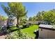 Beautifully landscaped backyard with lush artificial turf, cozy seating area, and inviting hot tub for outdoor enjoyment at 504 Painted Cloud Pl, Las Vegas, NV 89144