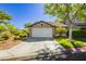 Charming single-story home featuring a well-maintained lawn, two-car garage, and desert landscaping at 504 Painted Cloud Pl, Las Vegas, NV 89144
