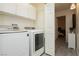 Bright laundry room features modern appliances and leads into another room, providing convenience at 504 Painted Cloud Pl, Las Vegas, NV 89144