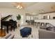 Open-concept living room with a grand piano, kitchen bar, and dining area with built-in bench seating at 504 Painted Cloud Pl, Las Vegas, NV 89144