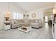Inviting living room boasts neutral colors, wood-look floors, natural light, and comfortable sectional sofa at 504 Painted Cloud Pl, Las Vegas, NV 89144