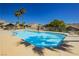Community swimming pool with sparkling blue water, lounge chairs, and palm trees under a clear blue sky at 504 Painted Cloud Pl, Las Vegas, NV 89144