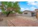 Backyard with brick patio, gravel, partial tree cover, and view of home's exterior at 5162 Somerset Dr, Las Vegas, NV 89120