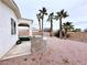 An outdoor kitchen area adds space to the gravel-covered backyard, lined with tall, thin palm trees and block wall fencing at 5704 Burdel St, Las Vegas, NV 89149