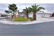 Charming single-story home with a well-manicured lawn and lush palm trees along the front at 5704 Burdel St, Las Vegas, NV 89149