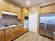 Well-equipped kitchen with stainless steel refrigerator, oak cabinets, and granite countertops at 5704 Burdel St, Las Vegas, NV 89149
