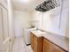 Well-equipped laundry room with a washer, sink, storage cabinets, and convenient shelving at 5704 Burdel St, Las Vegas, NV 89149