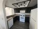 Galley style kitchen with black cabinets, white appliances, and new floors at 611 Bass Dr # C, Henderson, NV 89014