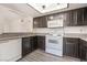 Modern kitchen features granite countertops, white appliances, and wood cabinets at 611 Bass Dr # C, Henderson, NV 89014