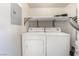 Bright laundry area features a washer, a dryer, and shelving at 611 Bass Dr # C, Henderson, NV 89014