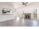 Bright living room featuring a brick fireplace, ceiling fan, and view into the kitchen at 611 Bass Dr # C, Henderson, NV 89014