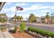 Street view of the neighborhood with mature trees, landscaping, and an American flag at 611 Bass Dr # C, Henderson, NV 89014