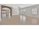 Expansive living area with a brick archway, tile flooring, neutral walls, and plenty of natural light at 6150 Bunker Commons Ct, Las Vegas, NV 89108