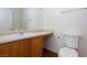 Bathroom featuring a sink with wood cabinets, toilet, and a large mirror at 6420 Extreme Shear Ave # 102, Henderson, NV 89011