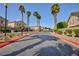 View of the community entrance with palm trees and well-maintained landscaping on a sunny day at 6420 Extreme Shear Ave # 102, Henderson, NV 89011