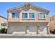 Exterior shot of a three-story home, featuring three garage doors and beige stucco at 6420 Extreme Shear Ave # 102, Henderson, NV 89011