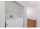 Laundry room with washer and dryer, shelves, with bedroom visible through open doorway at 6420 Extreme Shear Ave # 102, Henderson, NV 89011