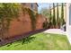 Lush backyard with pavers, artificial grass, and a climbing vine on the wall at 6731 Sumatra St, Las Vegas, NV 89166